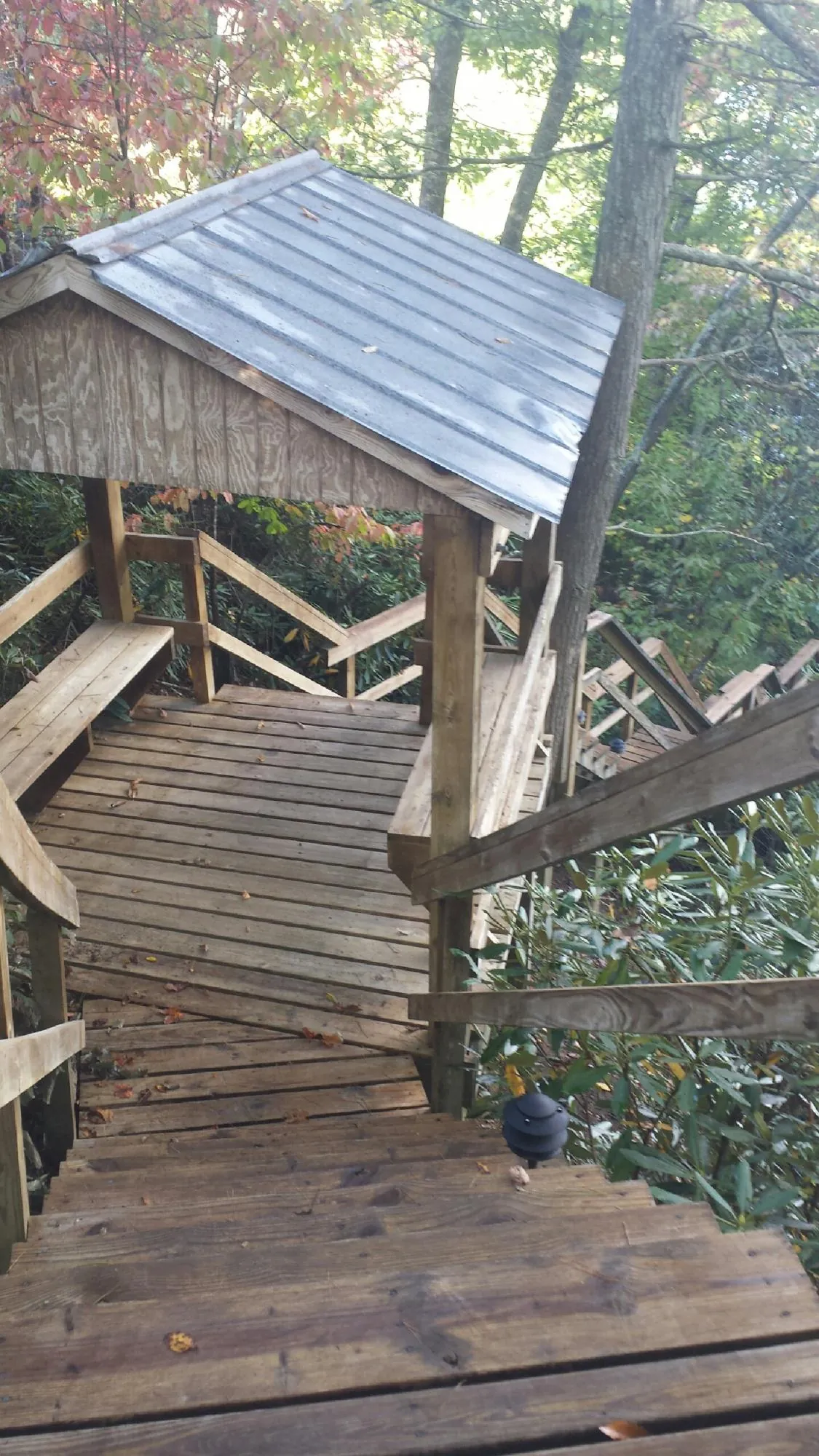 Metal roofed shelter over wooden steps on a wooded walkway — Skylight Repair & Installation work by our crew in Lambertville